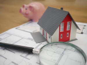 bank, tiny house, and magnifying glass signifying buying vs. renting in 2021